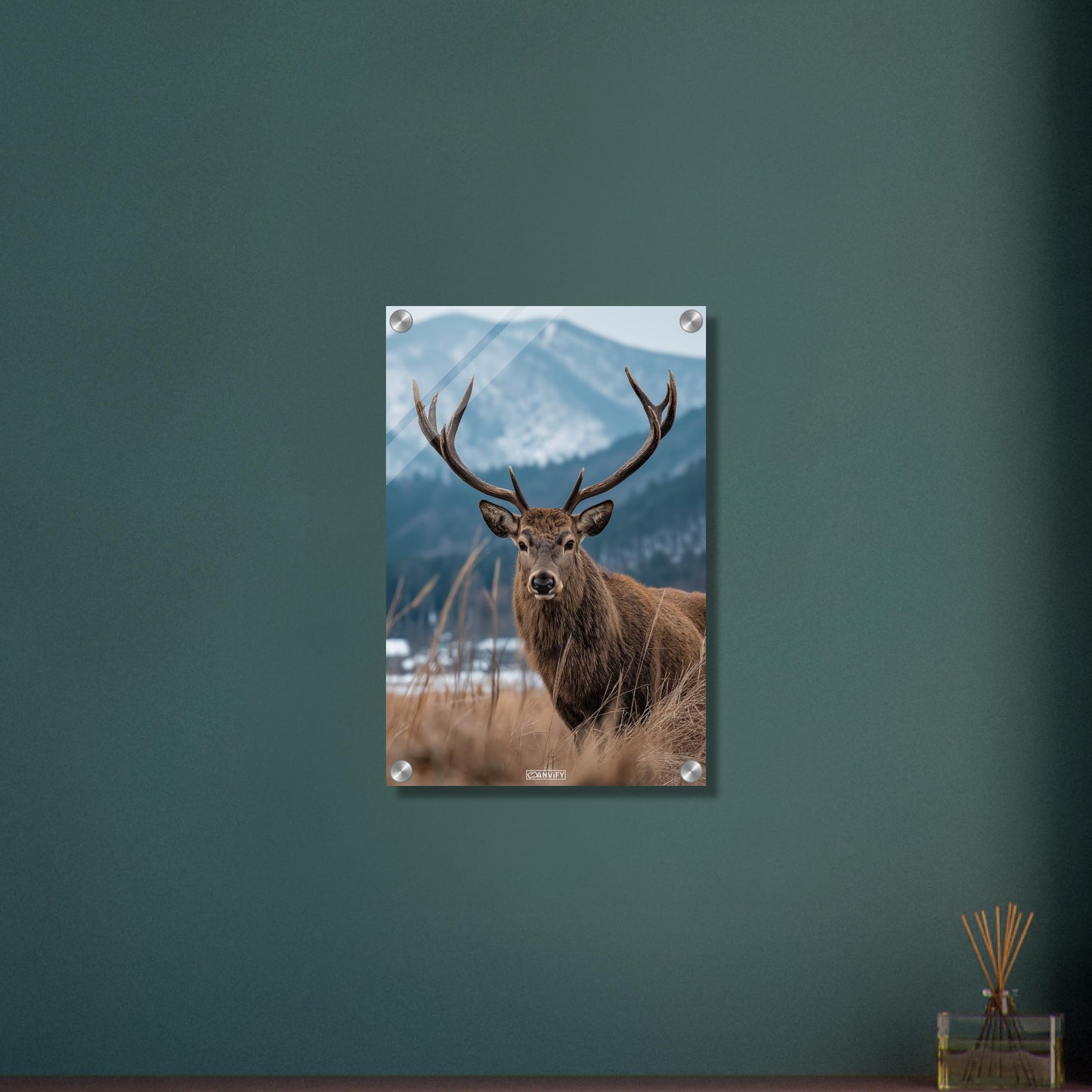 Hirsch mit großem Geweih am offenen Feld neben einem Nadelwald auf einem Acrylbild