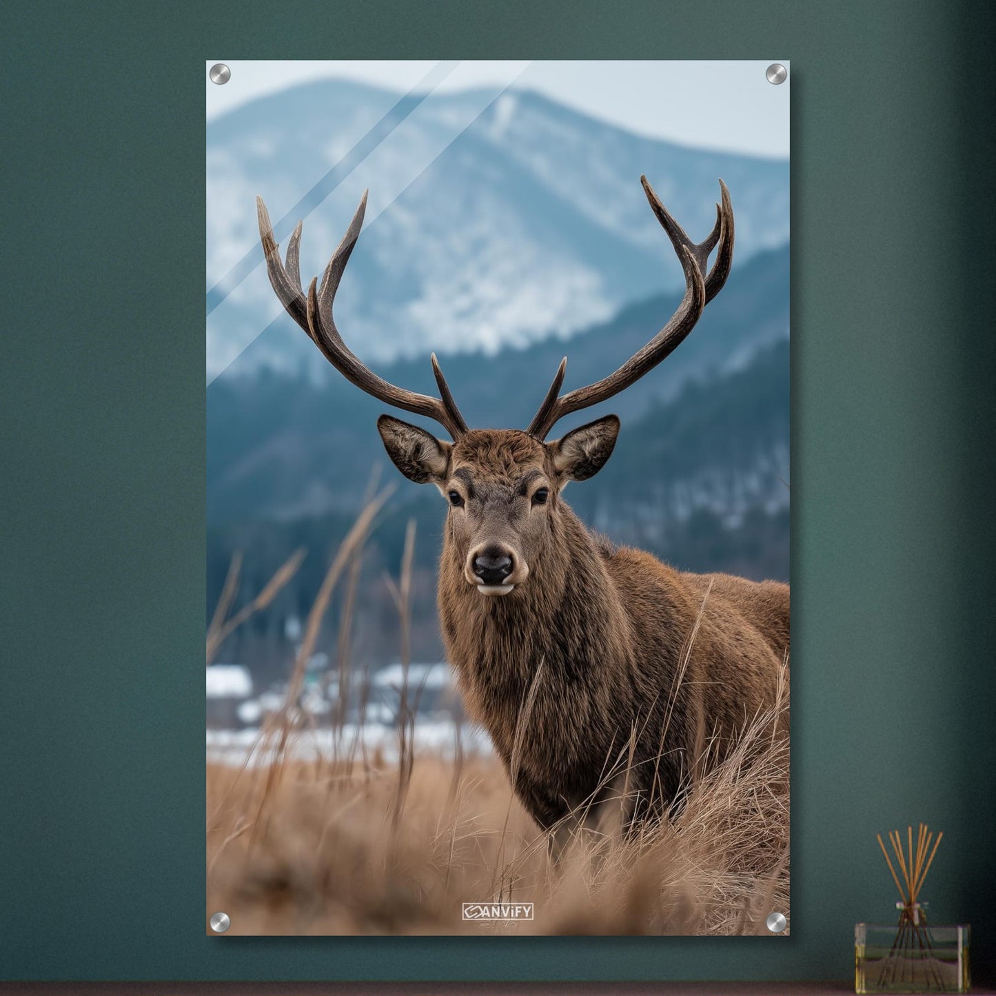 Hirsch mit großem Geweih am offenen Feld neben einem Nadelwald auf einem Acrylbild