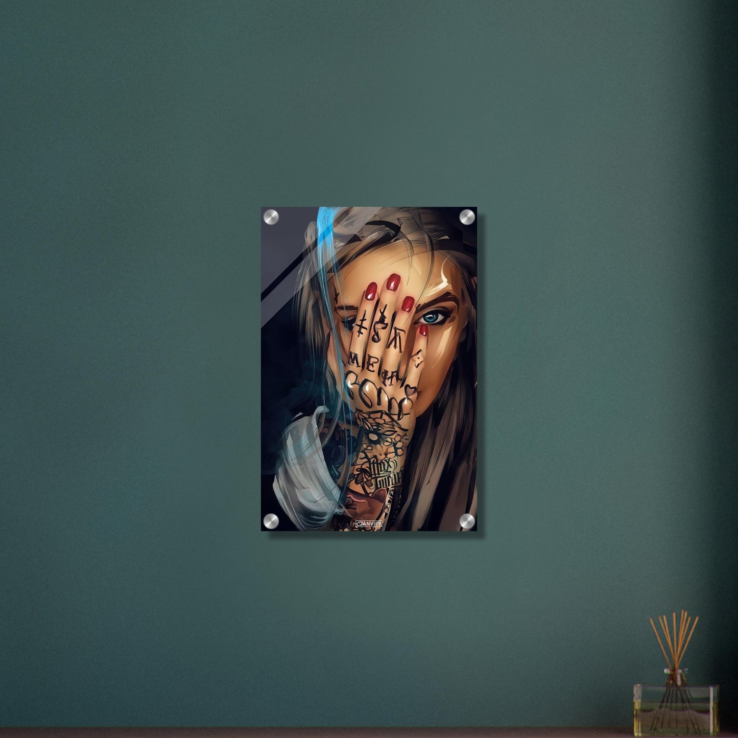 Schöne tätowierte Frau mit roten Fingernägeln und blauen Augen auf einem Acrylbild