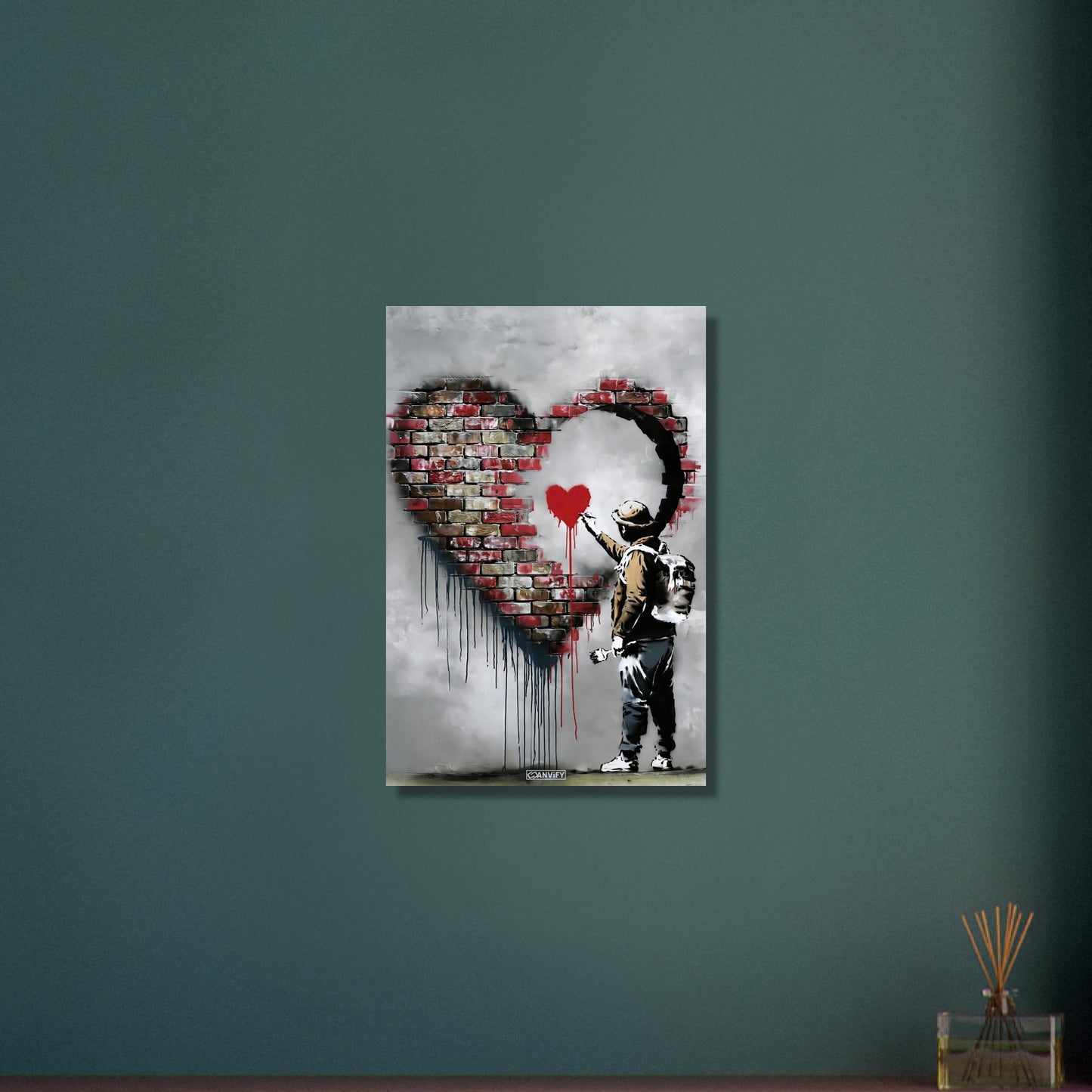 Künstler malt ein kleines rotes Herz in einem großen Herz aus Ziegelsteinen im Banksy Stil auf Aluminium