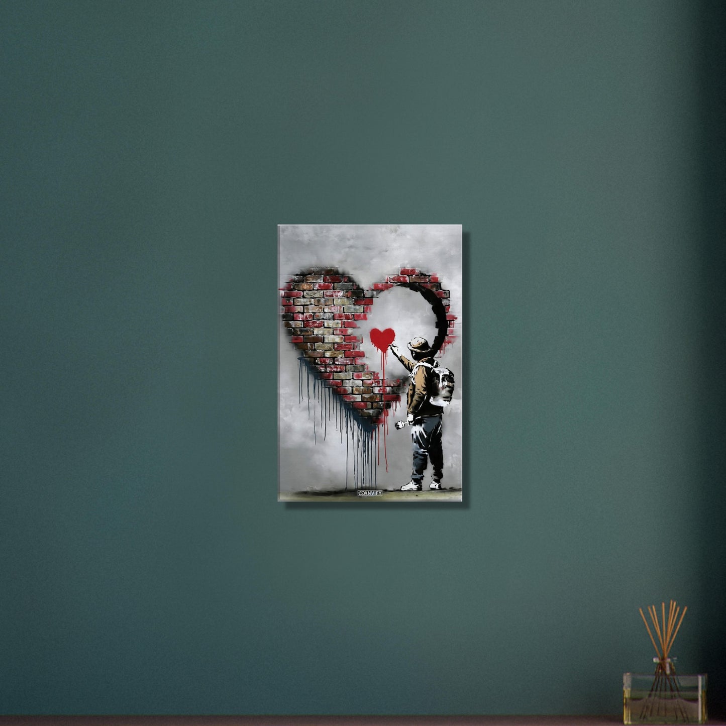 Künstler malt ein kleines rotes Herz in einem großen Herz aus Ziegelsteinen im Banksy Stil auf einer Leinwand
