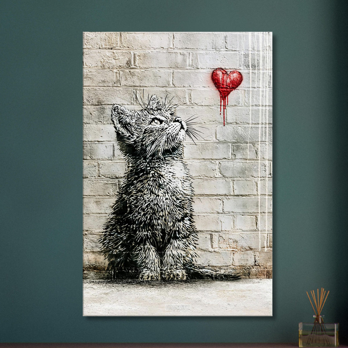 Kleine Katze im Banksy Stil blickt auf ein rotes Herz hoch auf einer Leinwand
