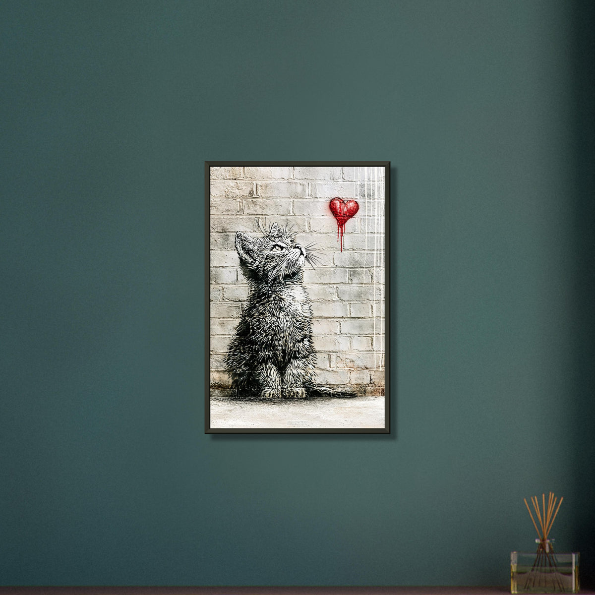 Kleine Katze im Banksy Stil blickt auf ein rotes Herz hoch auf einem Poster im Metallrahmen