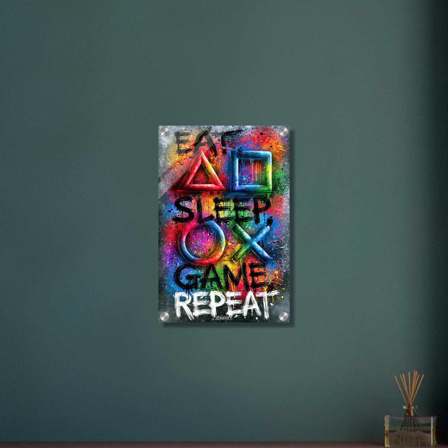 Spruch mit Symbolen der Playstation 'Eat, Sleep, Game, Repeat' mit bunten Farben auf einem Acrylbild
