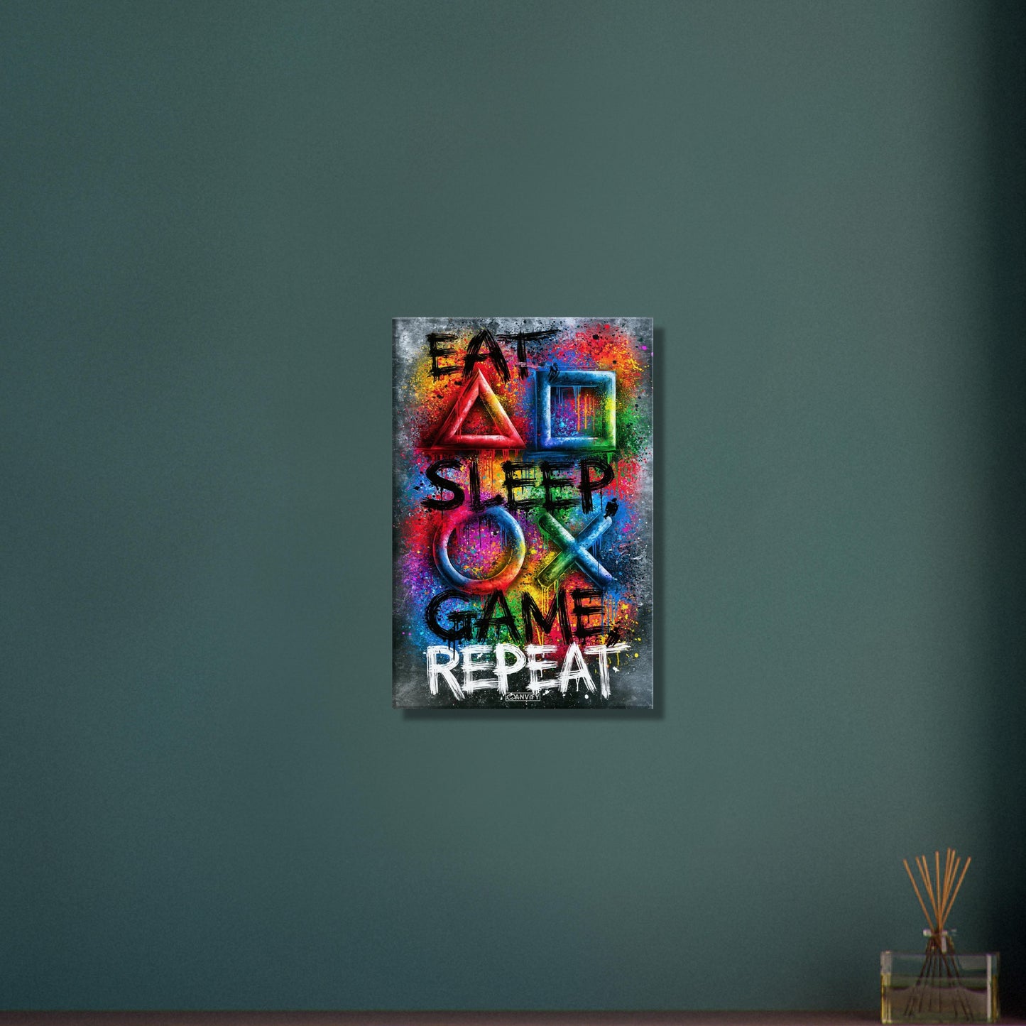 Spruch mit Symbolen der Playstation 'Eat, Sleep, Game, Repeat' mit bunten Farben auf einer Leinwand