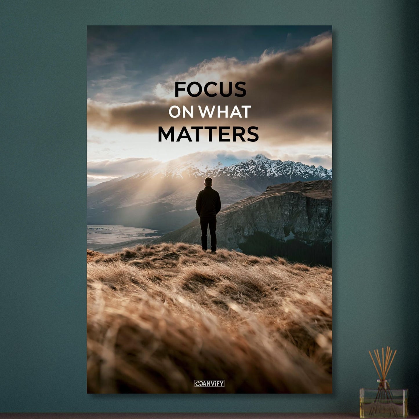Mann steht auf der Klippe mit dem Rücken zur Kamera und blickt auf den Sonnenaufgang mit dem Motivationsspruch "Focus On What Matters" auf Aluminium
