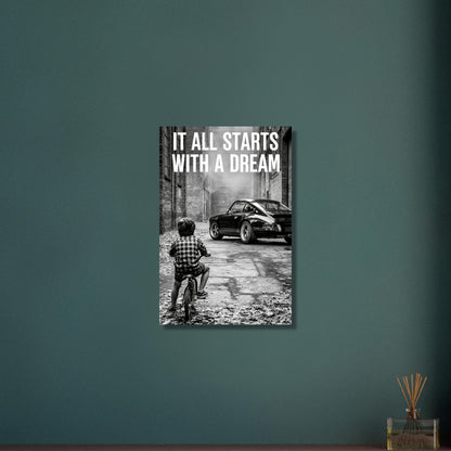 Kleiner Junge auf dem Fahrrad blickt auf einen Porsche 911 mit dem Motivationsspruch "It All Starts With A Dream" auf Aluminium