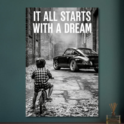 Kleiner Junge auf dem Fahrrad blickt auf einen Porsche 911 mit dem Motivationsspruch "It All Starts With A Dream" auf Aluminium