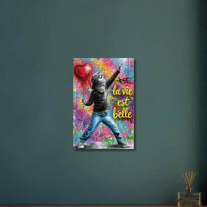 Kleiner Junge mit Basecap, Bandana und einem Herzluftballon in der Hand und einem Spruch "La Vie Est Belle" im Pop Art Stil auf Aluminium