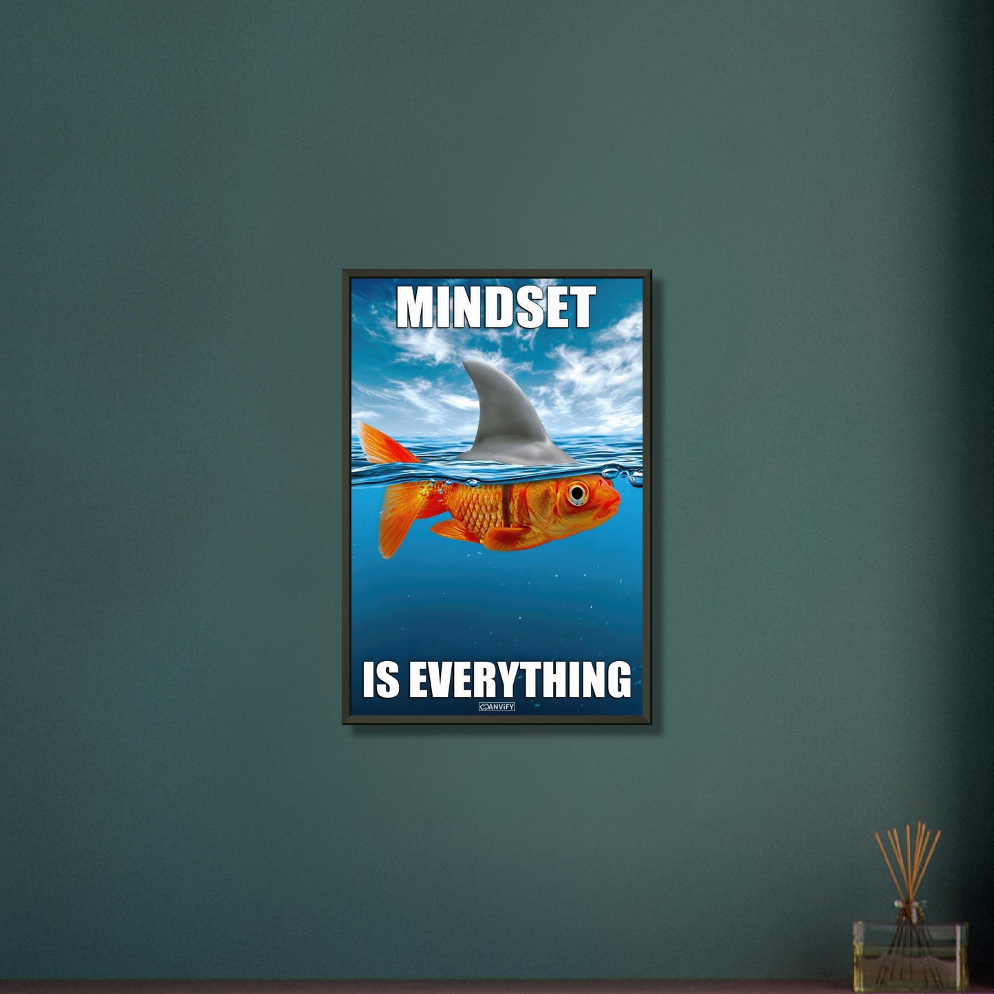 Goldfisch im Meer und mit einer Haiflosse am Rücken mit dem Spruch "Mindset Is Everything" auf einem Poster im Metallrahmen
