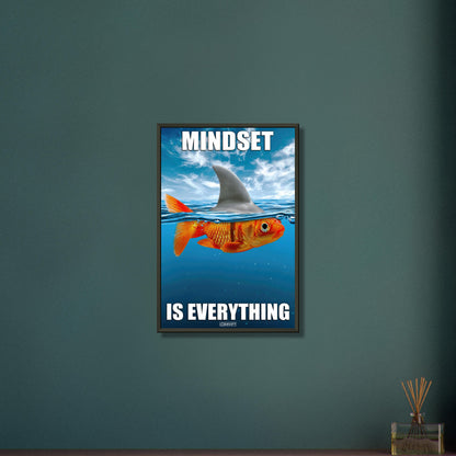 Goldfisch im Meer und mit einer Haiflosse am Rücken mit dem Spruch "Mindset Is Everything" auf einem Poster im Metallrahmen