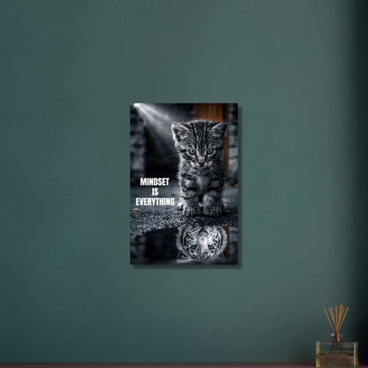 Katzenbaby blickt in eine Wasserpfütze und sieht sich darin als einen großen Tiger mit einem Motivationsspruch "Mindset Is Everything" auf Aluminium