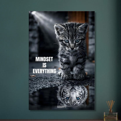 Katzenbaby blickt in eine Wasserpfütze und sieht sich darin als einen großen Tiger mit einem Motivationsspruch "Mindset Is Everything" auf einer Leinwand