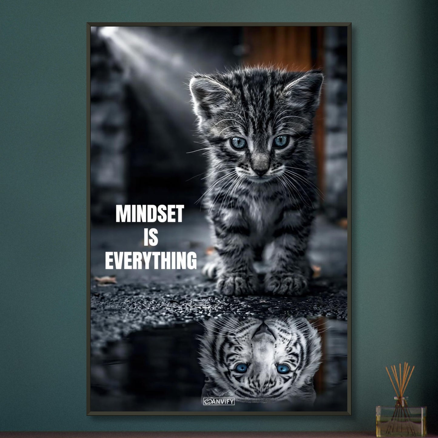 Katzenbaby blickt in eine Wasserpfütze und sieht sich darin als einen großen Tiger mit einem Motivationsspruch "Mindset Is Everything" auf einem Poster im Metallrahmen