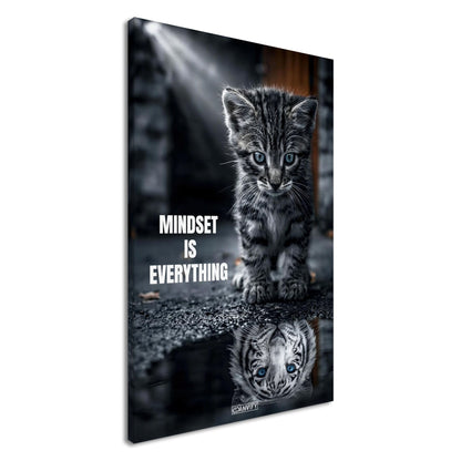 Katzenbaby blickt in eine Wasserpfütze und sieht sich darin als einen großen Tiger mit einem Motivationsspruch "Mindset Is Everything" auf einer Leinwand