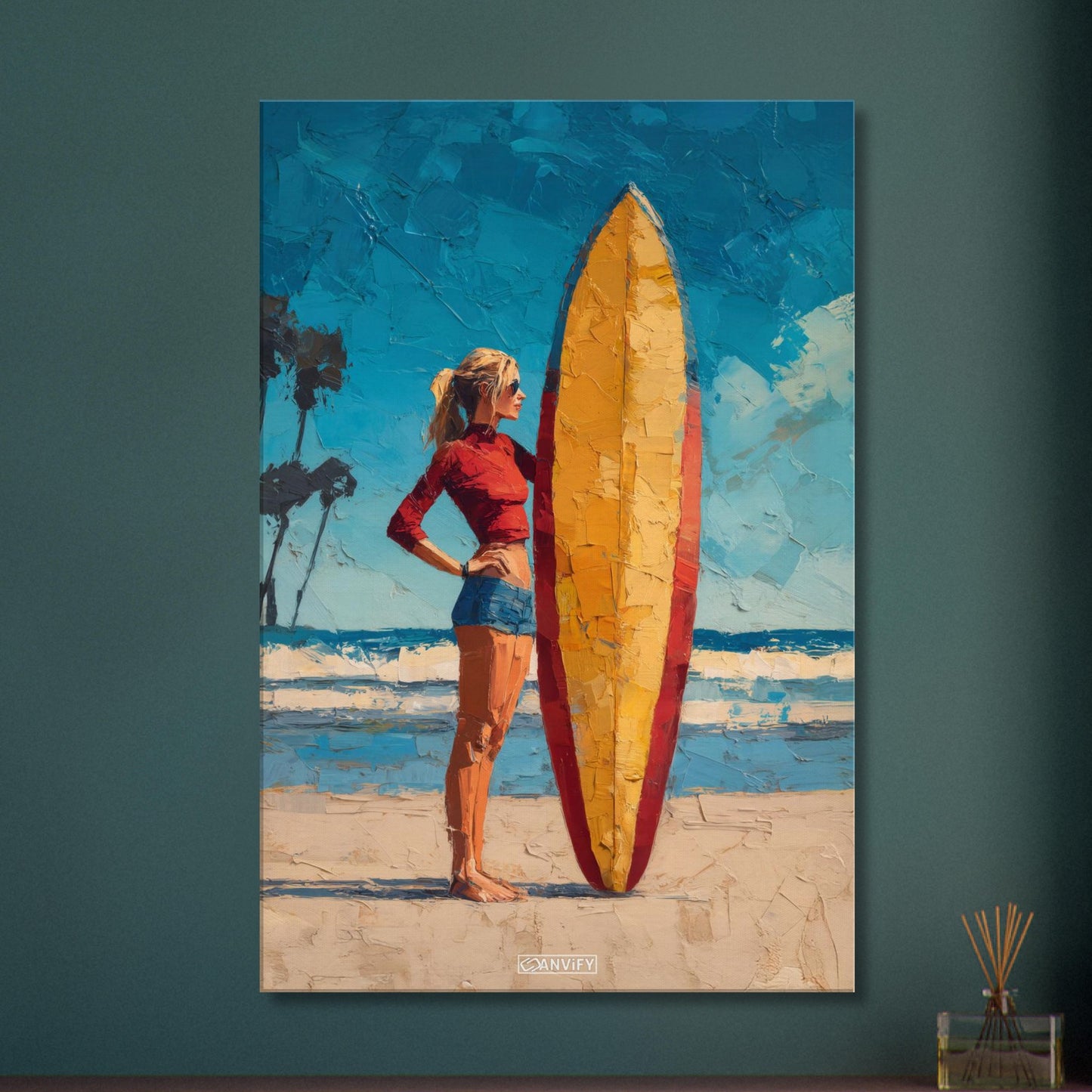 Surfermädchen mit rotem Top und blauer Hotpants und mit einem Surfbrett am Strand auf einer Leinwand