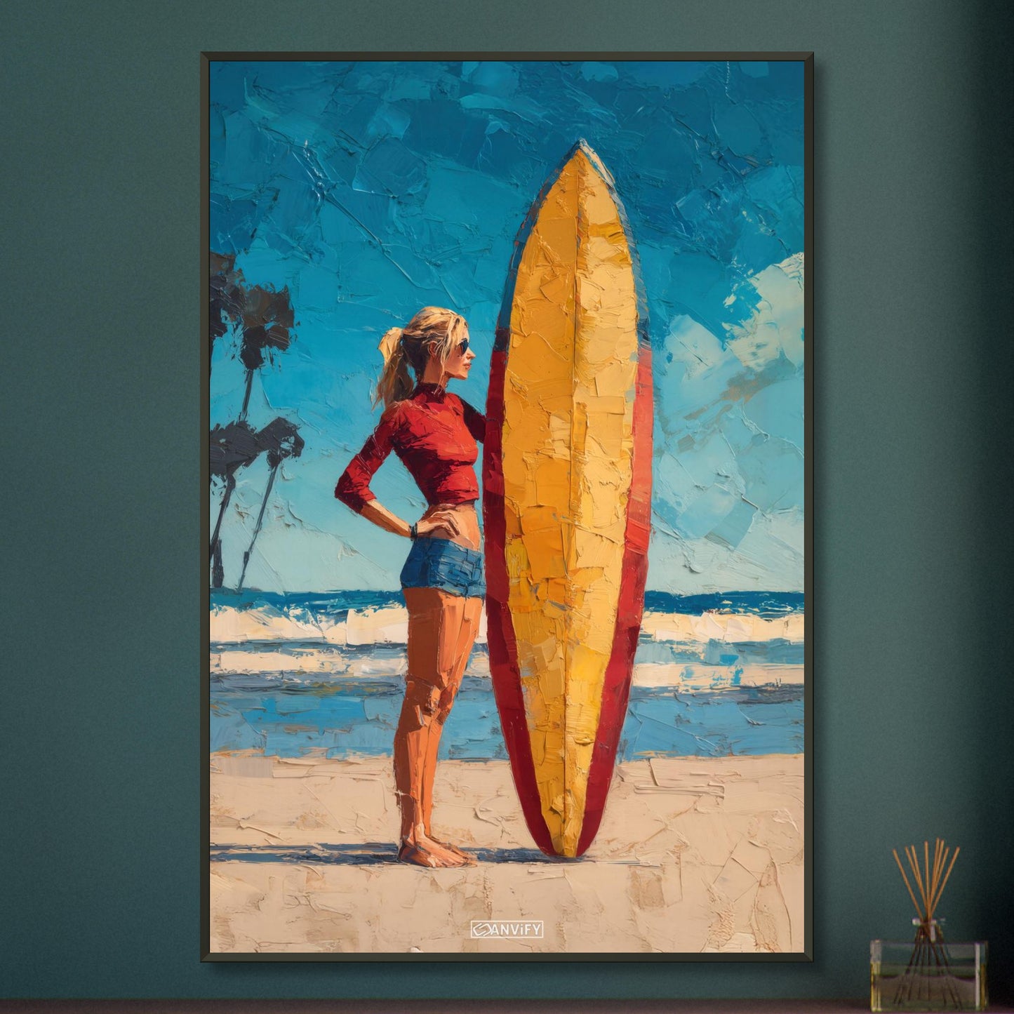 Surfermädchen mit rotem Top und blauer Hotpants und mit einem Surfbrett am Strand auf einem Poster im Metallrahmen