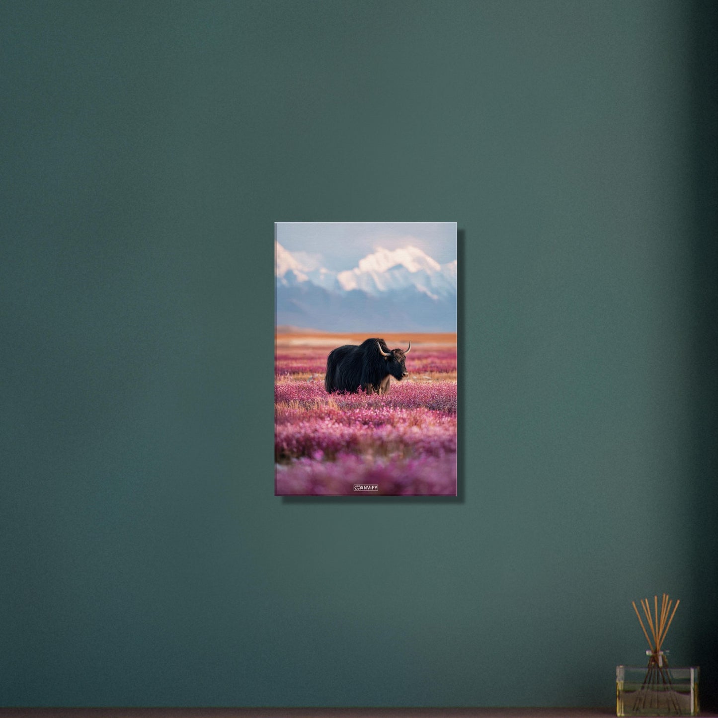 Schwarzer tibetanischer Yak auf einer Blumenwiese mit schneebedeckten Bergen im Hintergrund auf einer Leinwand