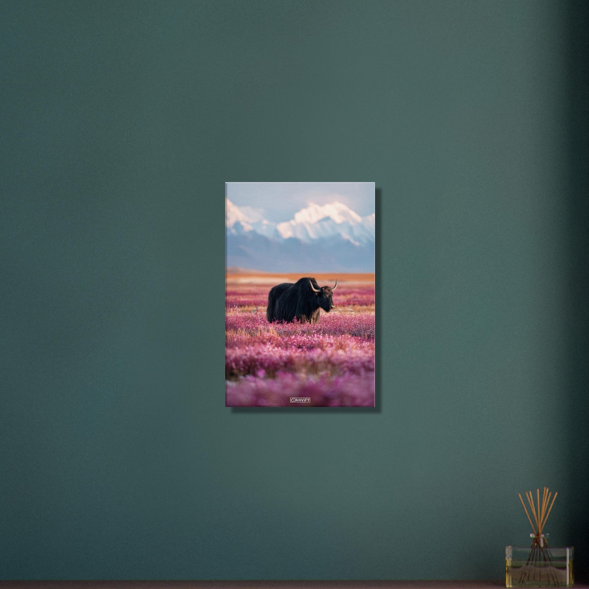 Schwarzer tibetanischer Yak auf einer Blumenwiese mit schneebedeckten Bergen im Hintergrund auf einer Leinwand