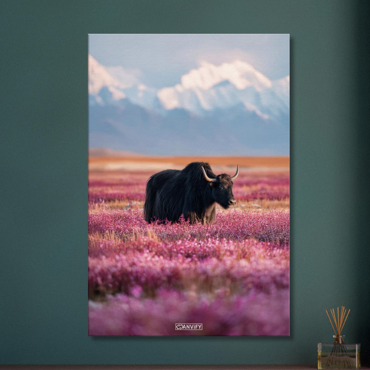Schwarzer tibetanischer Yak auf einer Blumenwiese mit schneebedeckten Bergen im Hintergrund auf einer Leinwand