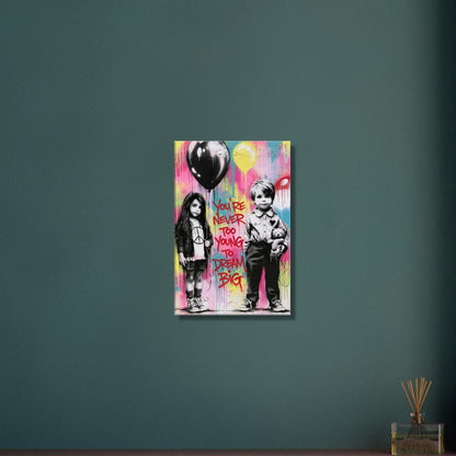 Junge mit einem Teddybär und ein Mädchen mit einem Luftballon in der Hand im Banksy Stil mit einem Spruch "You Are Never Too Young To Dream Big" auf einer Leinwand