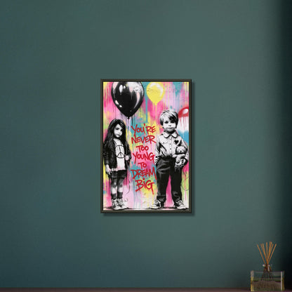 Junge mit einem Teddybär und ein Mädchen mit einem Luftballon in der Hand im Banksy Stil mit einem Spruch "You Are Never Too Young To Dream Big" auf einem Poster im Metallrahmen