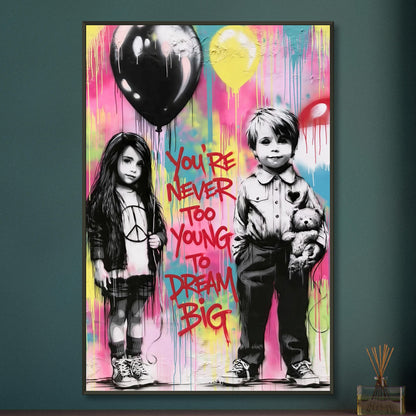 Junge mit einem Teddybär und ein Mädchen mit einem Luftballon in der Hand im Banksy Stil mit einem Spruch "You Are Never Too Young To Dream Big" auf einem Poster im Metallrahmen